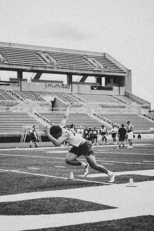 an athlete in black and white jumping over a hurdle