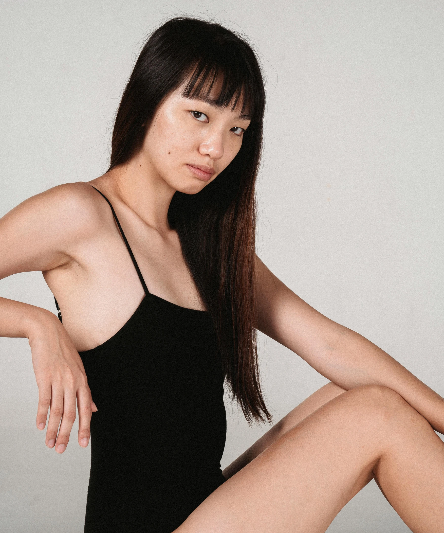an asian woman is posing in a black dress