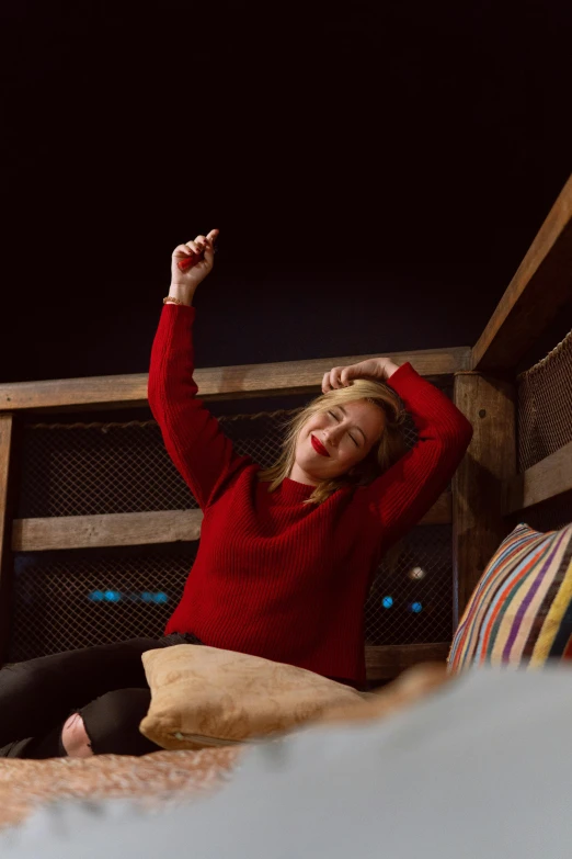 the woman is smiling while laying down with her arm in the air