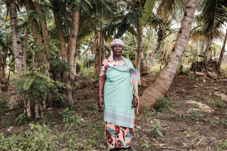 a woman standing under trees in the woods