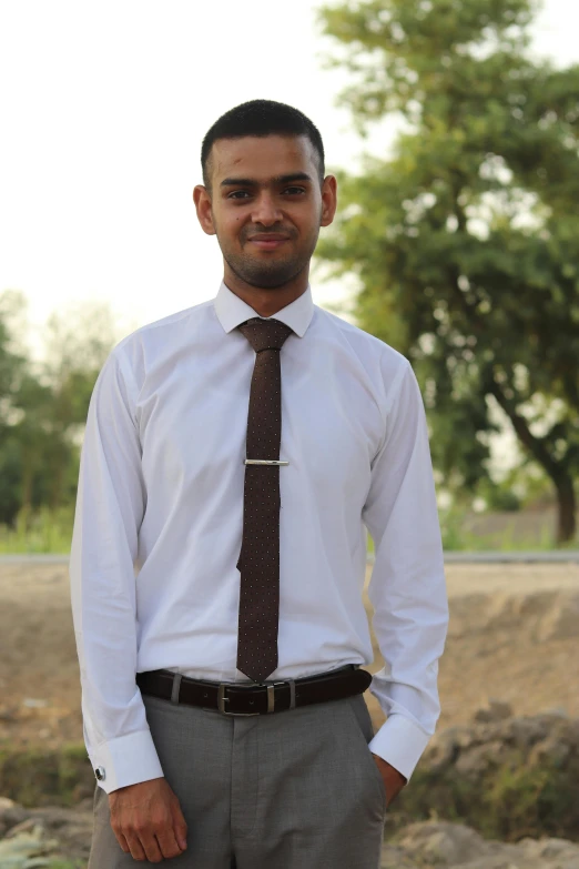 man in white shirt and tie standing outside