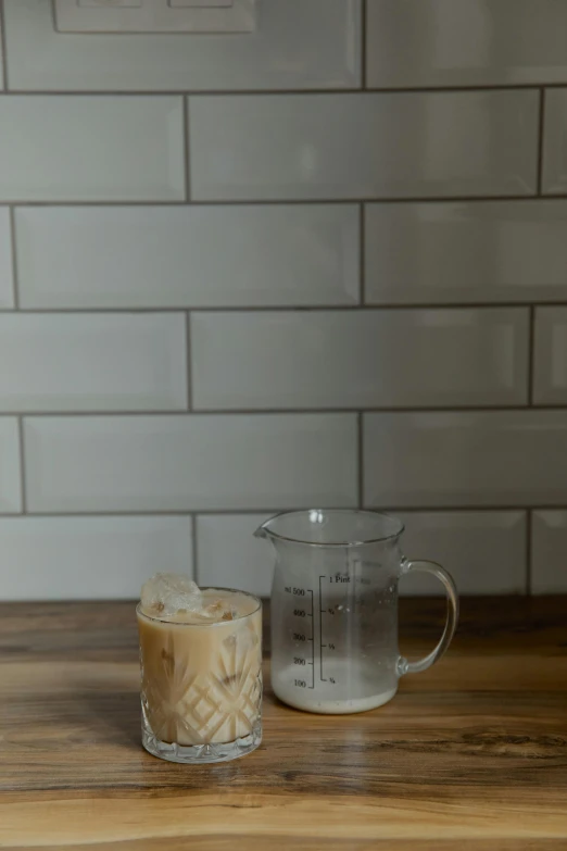 a glass of coffee with an ice cream container sitting next to it