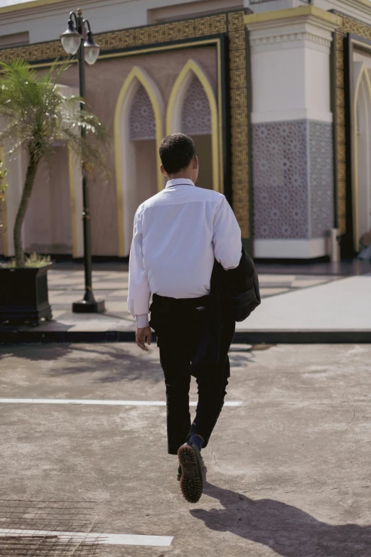 a man is walking in a suit outside