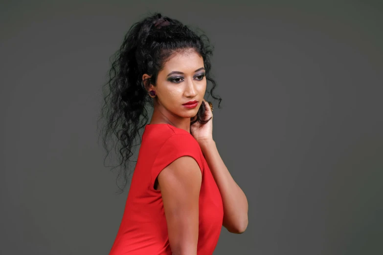 a young woman poses in a red dress