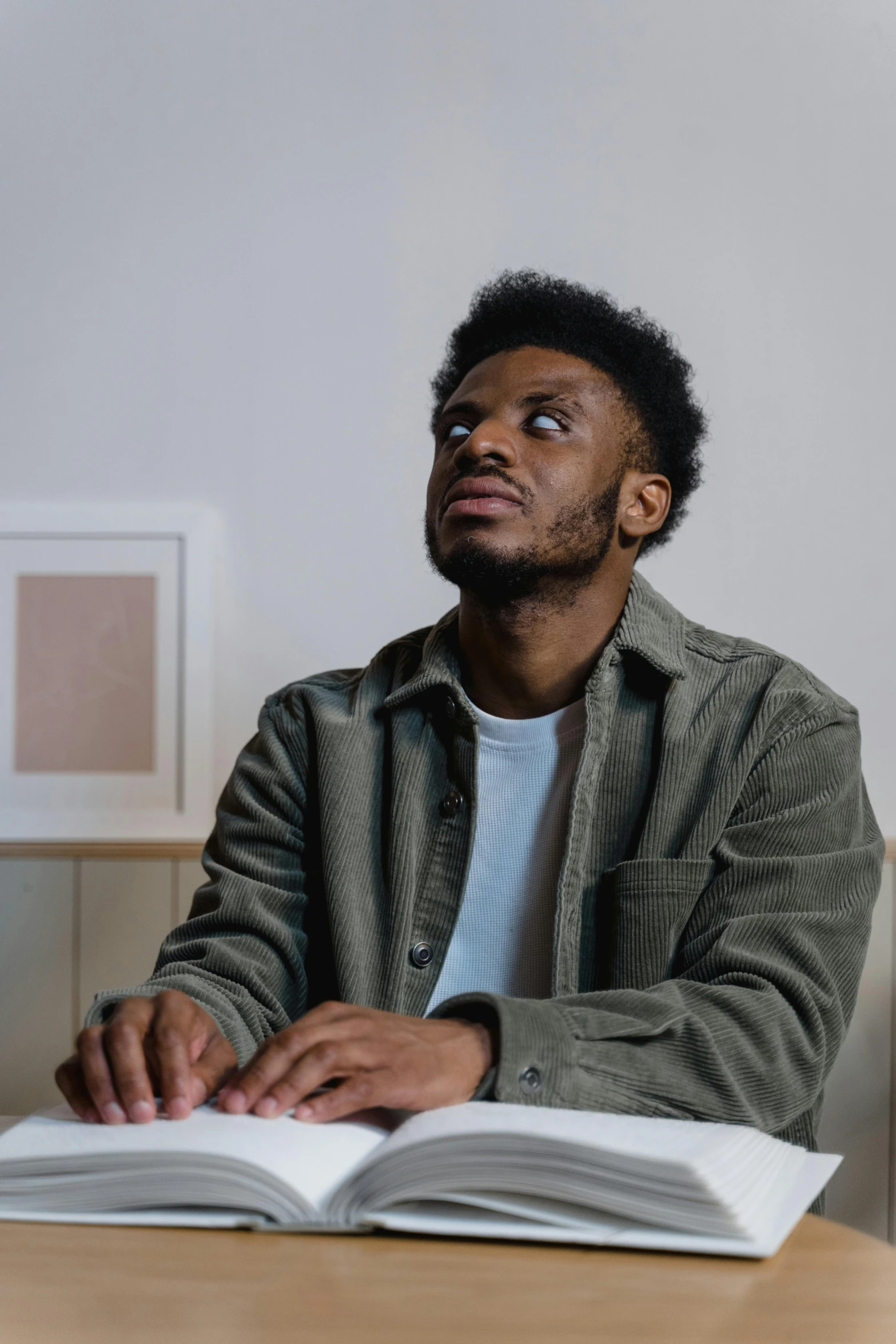 an african american male with a surprised expression holding a book