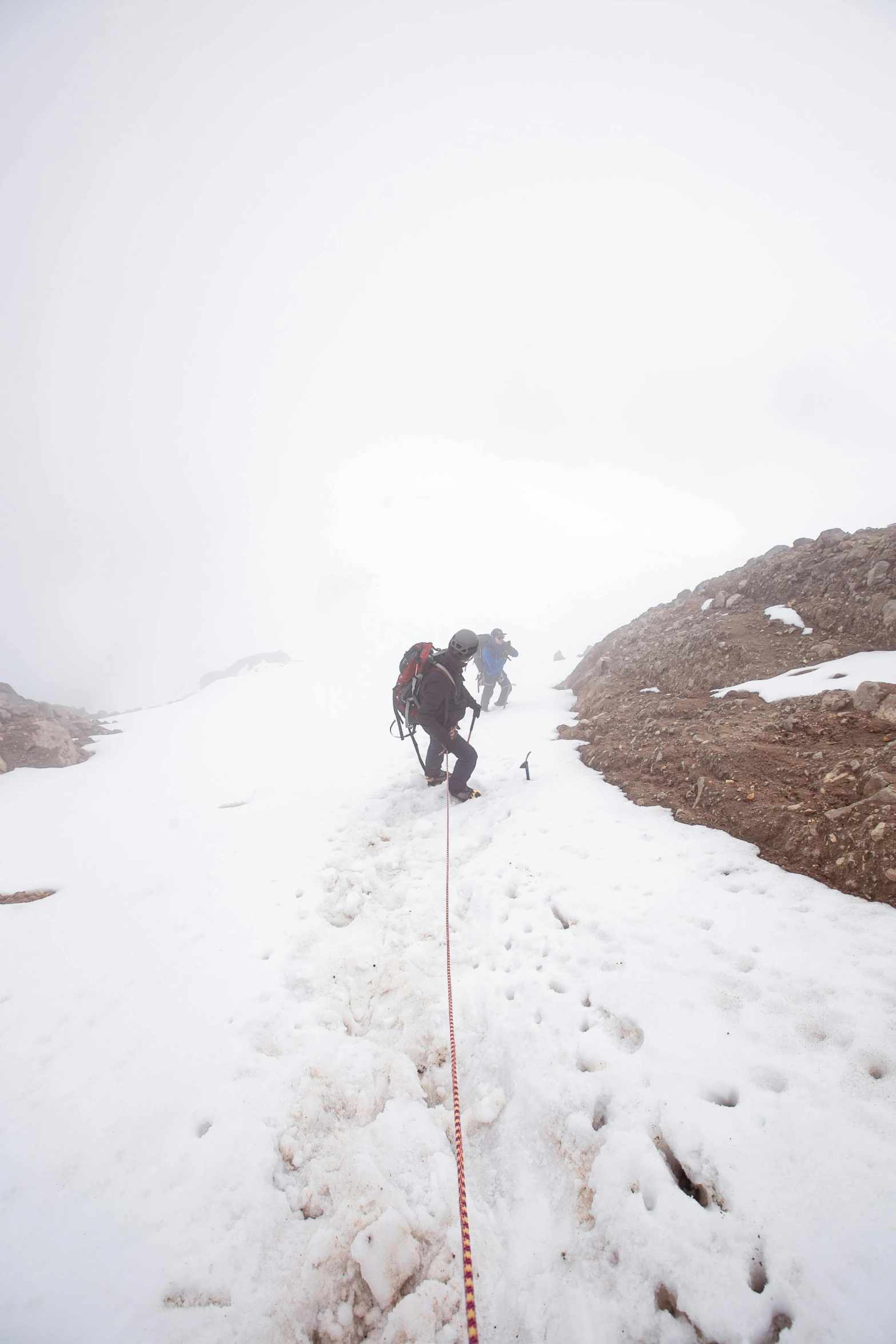 a man walking up a snow covered slope