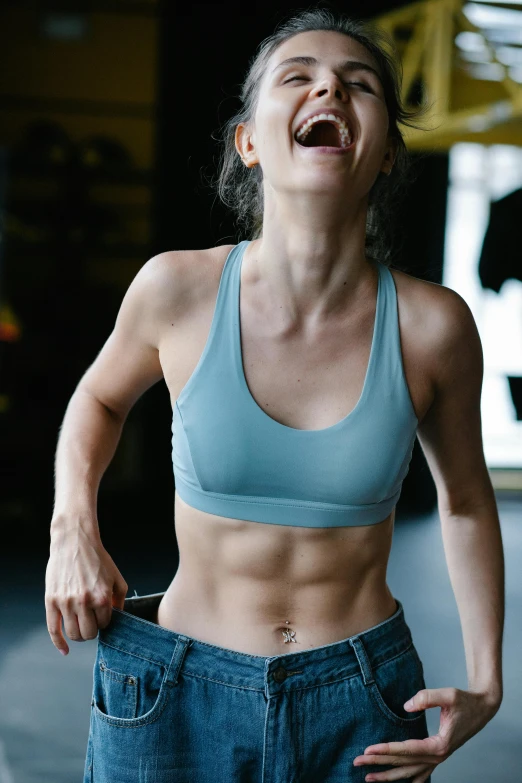 a woman with a smile laughing and holding onto a pair of jeans