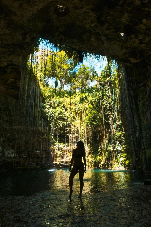 woman walking through a creek in the jungle