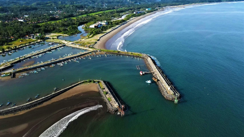 a pier sitting next to the beach in the middle of an ocean