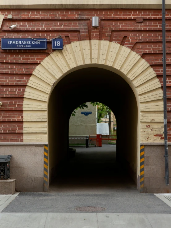 an arched tunnel is leading to a bench on a sidewalk