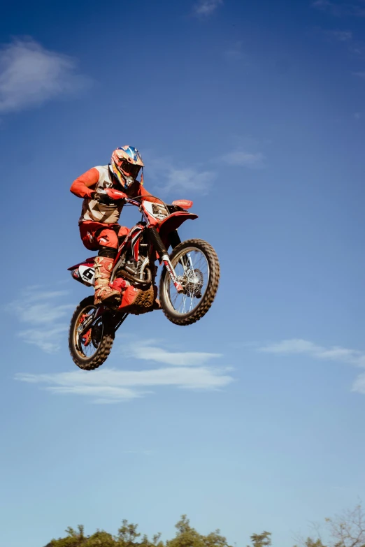 the dirt bike rider is flying through the air