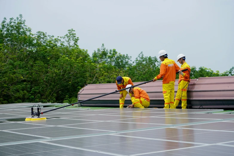 three men are working on a solar panel