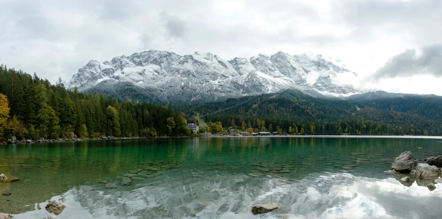 a beautiful mountain lake with water, trees and clouds