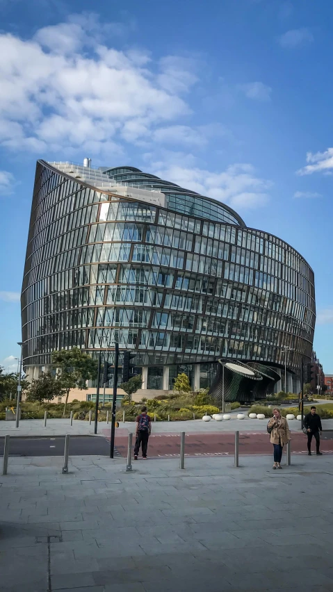 a curved building stands against a blue sky