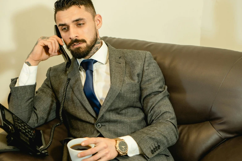 a man sitting on a couch talking on a phone