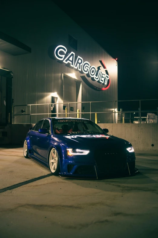 an car parked at a gas station by a garage