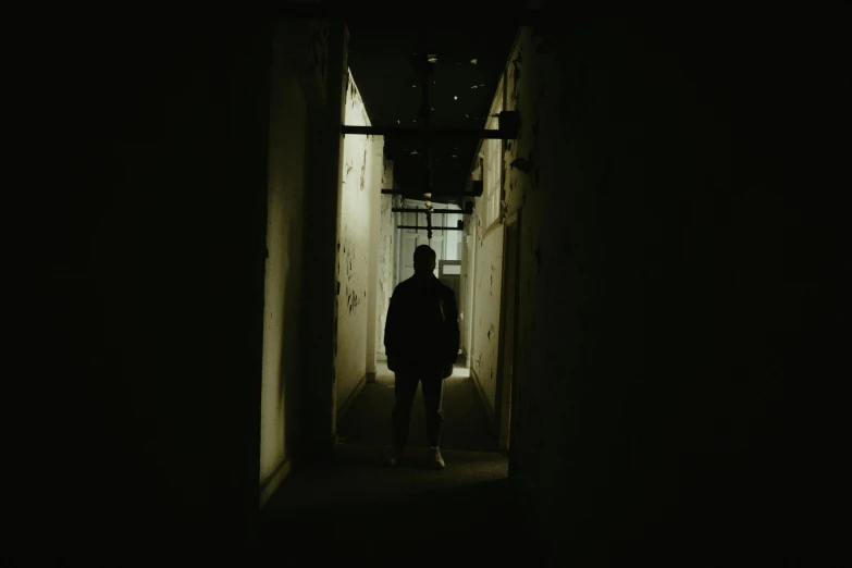 a person stands in a darkened passageway with no light on