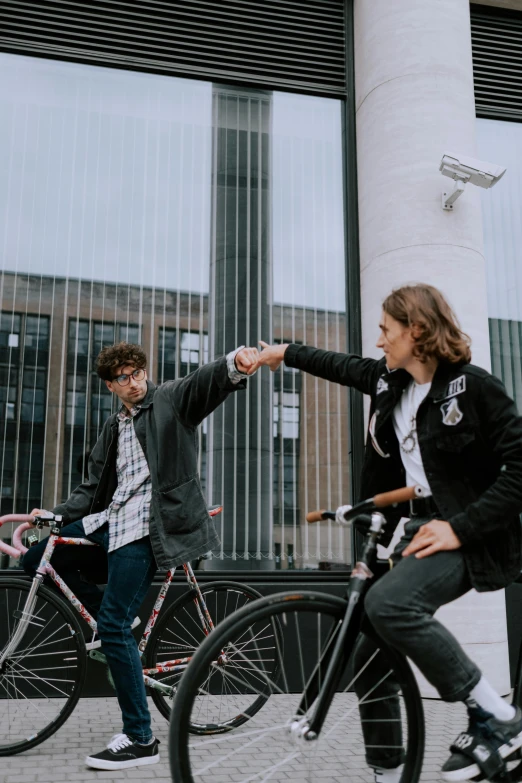 two people on bicycles on a city sidewalk