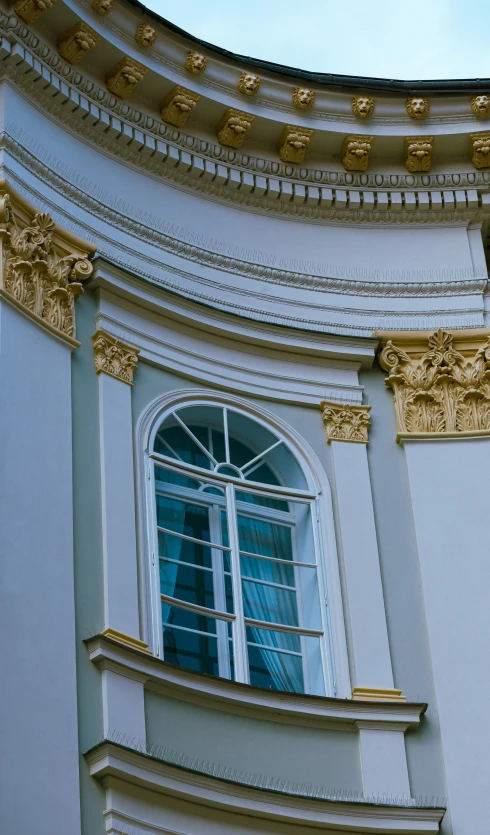 an ornate window that has gold trim around the window