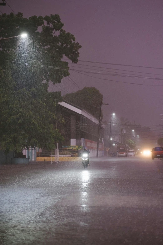 the people are walking through the rain at night