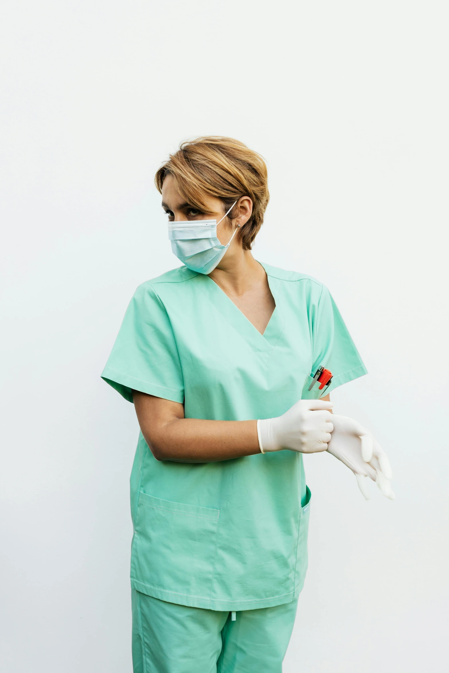 a woman is wearing surgical clothing and gloves