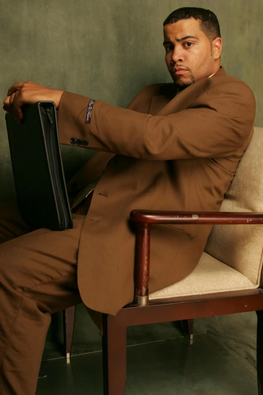 a man is sitting in a chair with a bag on his lap