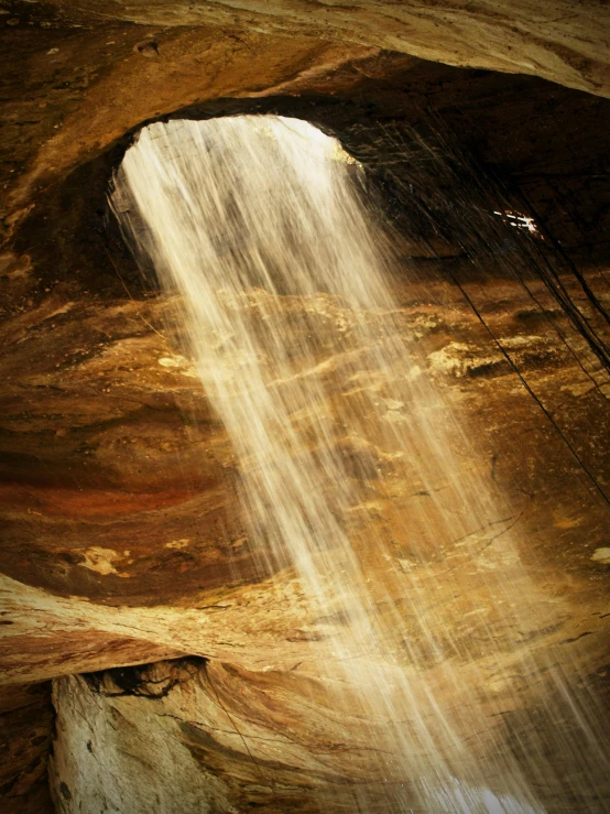 sunlight falls down on the water in a cave