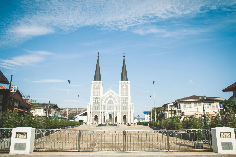 a church sitting next to a fence near many buildings