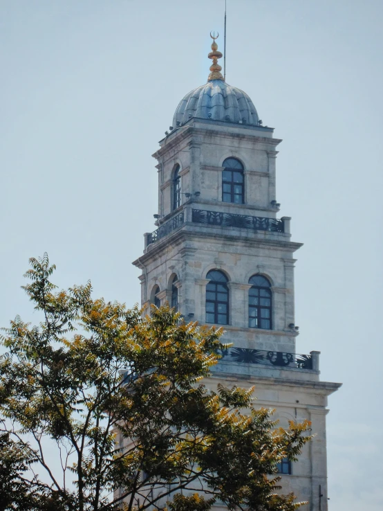 an old, grey church with gold spire against the sky