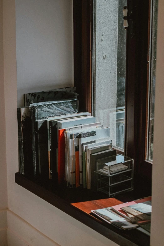 the window and bookcase in a living room are covered by the rain