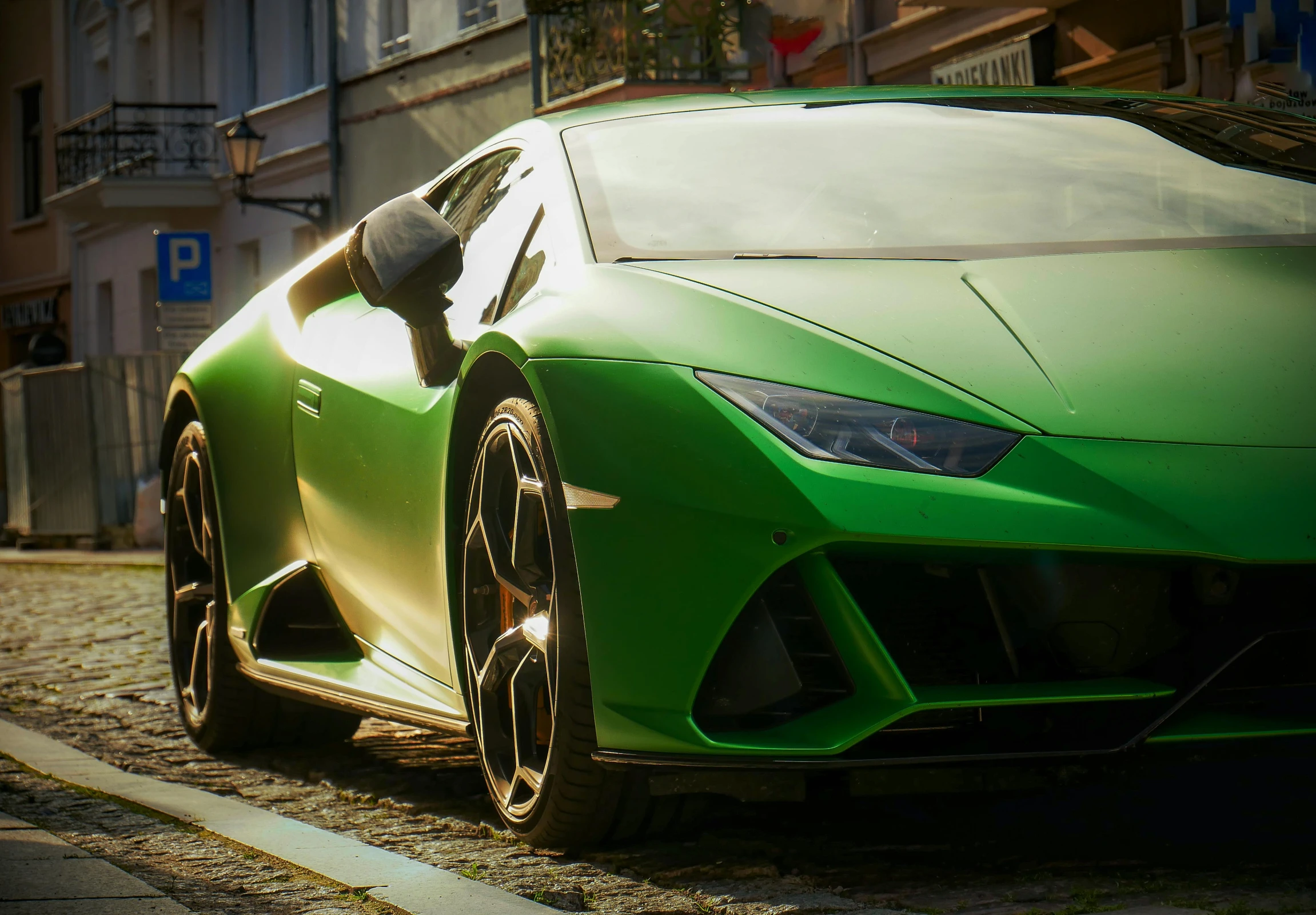 the face of a green sports car parked in a street