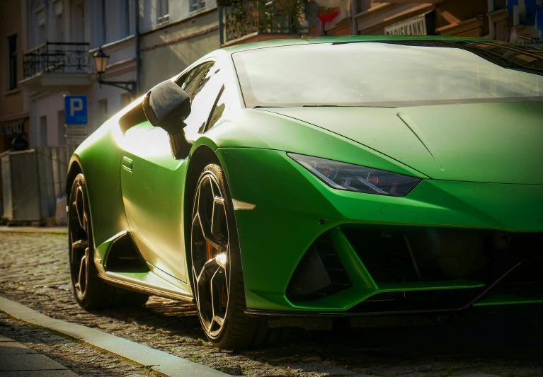 the face of a green sports car parked in a street