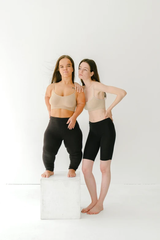 two women standing next to each other while posing