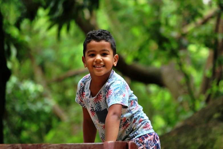 boy smiling with chest on the deck in the forest