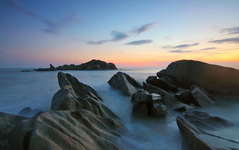 long exposure pograph of rocky shoreline at sunset