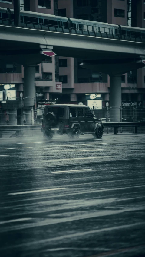 a jeep driving in a dle of water by a street light