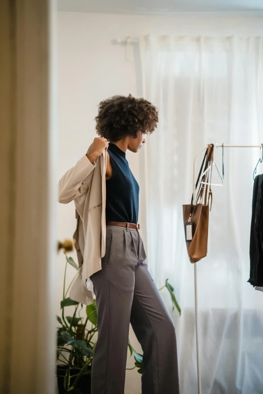 an african american woman is looking down at her pants