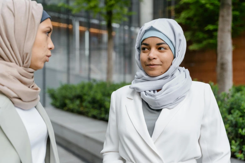 a woman wearing a headscarf standing next to another woman