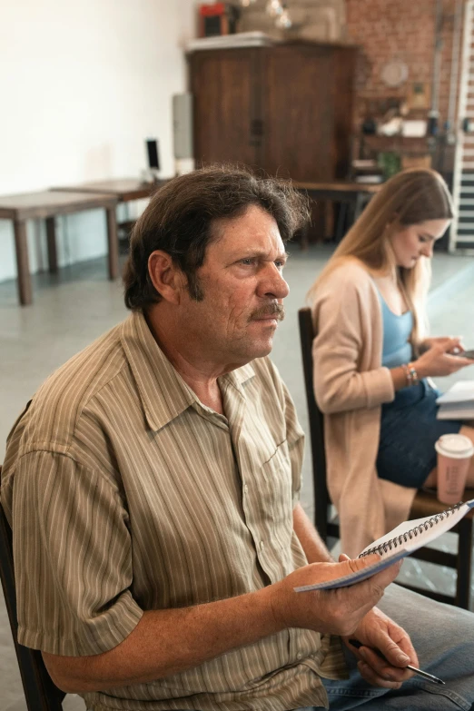 a man sitting in a chair in front of a woman