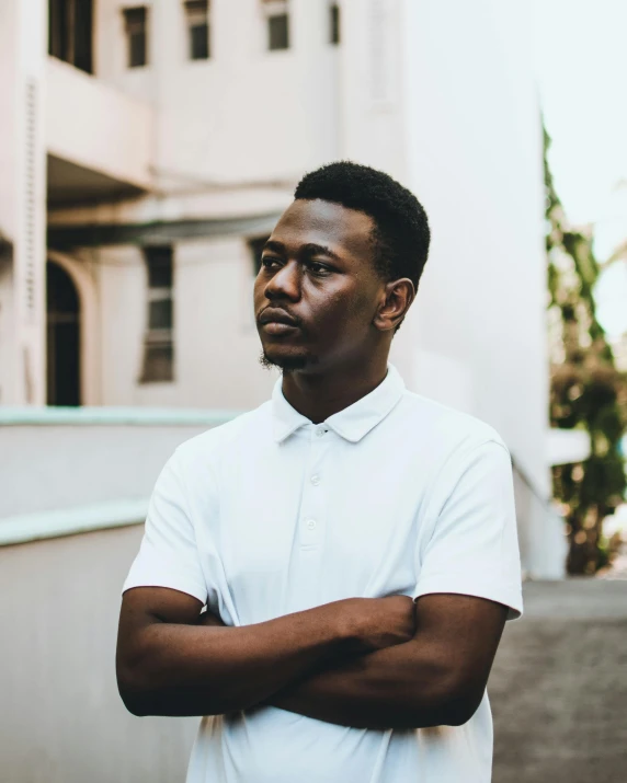 a black man is leaning against his chest looking off into the distance