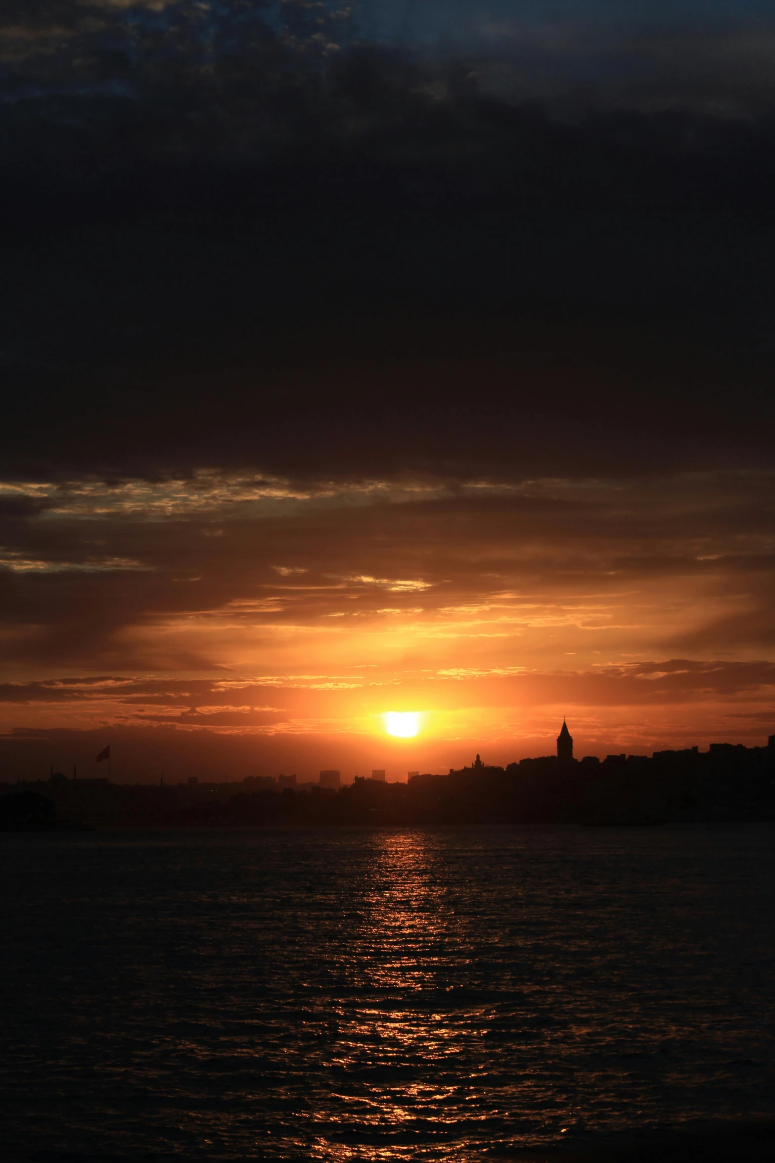 a setting sun in the sky behind the clouds