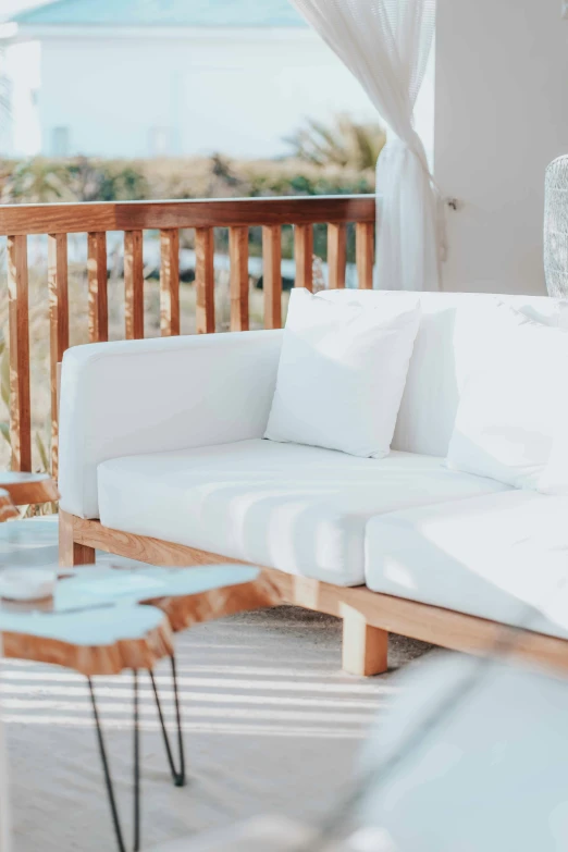 an outdoor couch on the deck with some white cushions