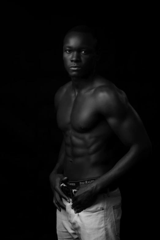 a shirtless man is standing against a black background