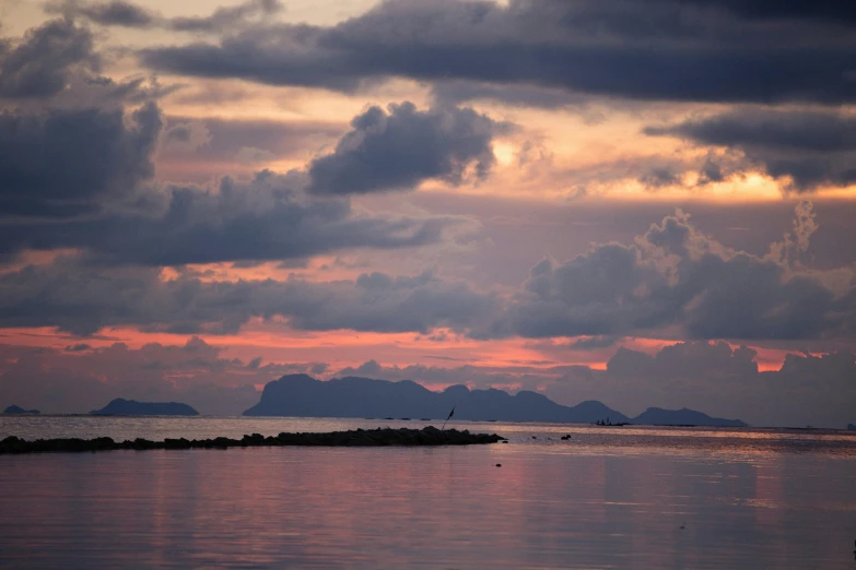 pink sunset with cloudy clouds over small islands