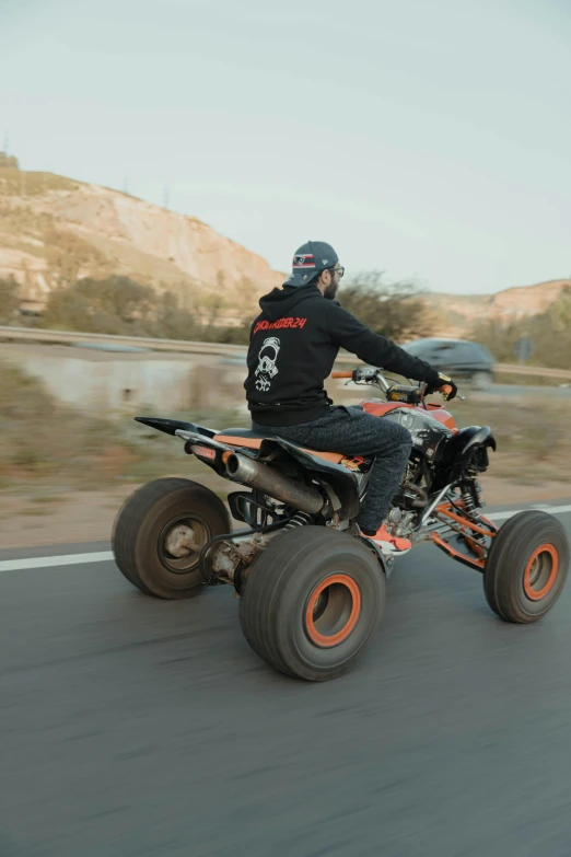 the man is riding on a four wheel motorcycle