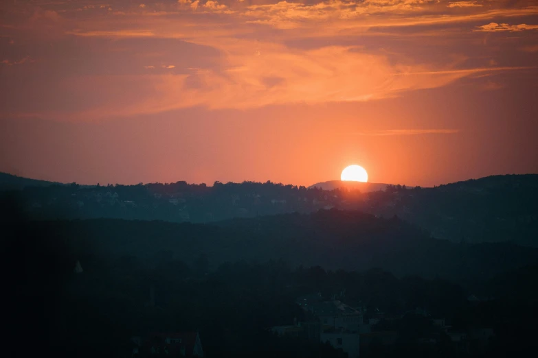 the sun set with no clouds behind a mountain