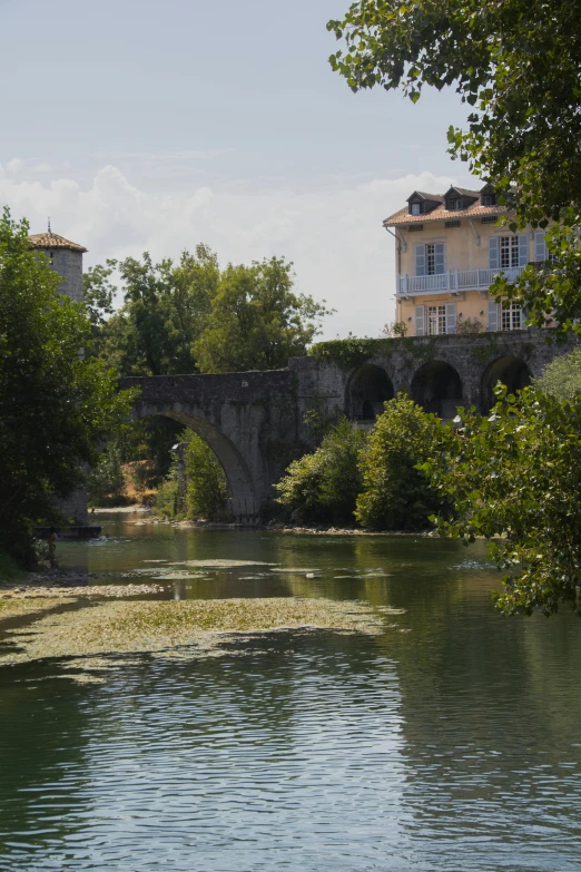 a building by the water surrounded by trees