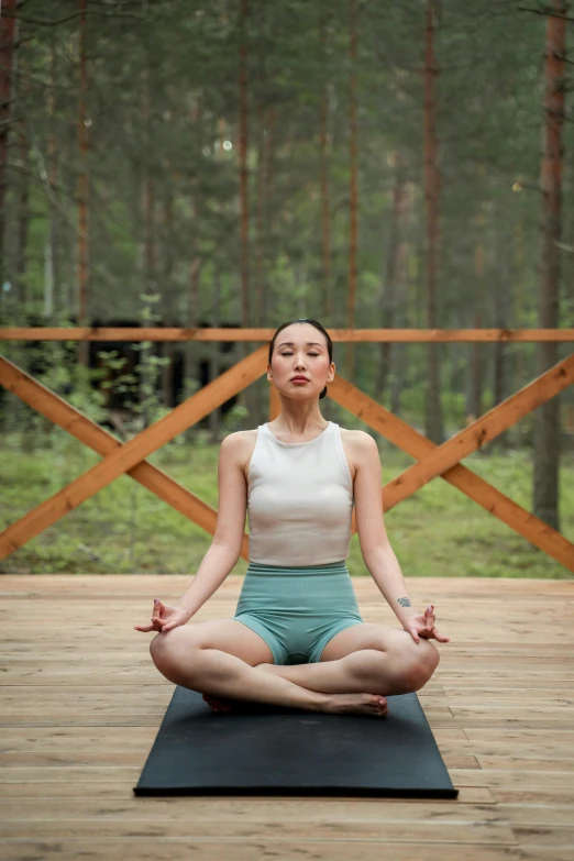 a woman is doing yoga in the woods