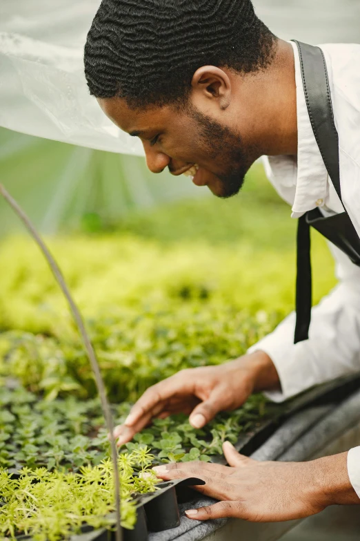 a man is tending to plants while holding soing