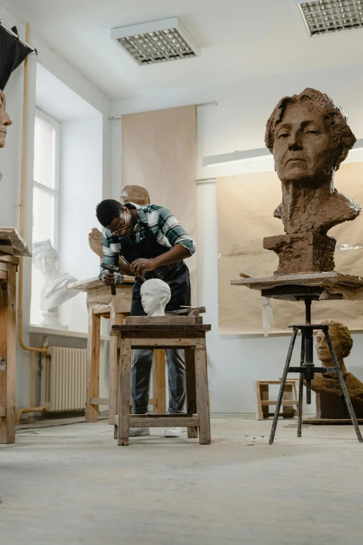 a group of men painting a head on a large sculpture